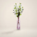 White blossom and berry artificial arrangement in tall pink glass vase